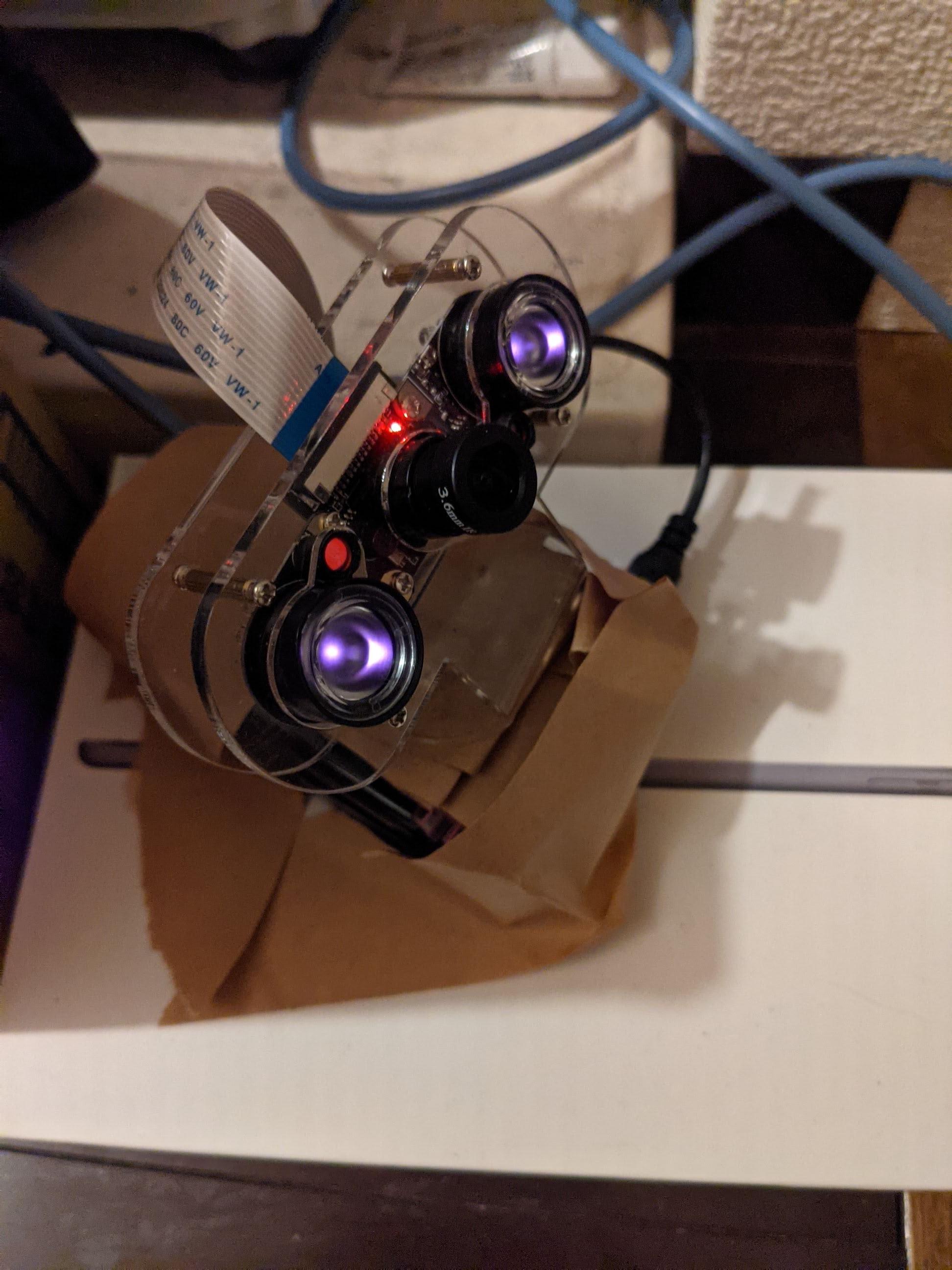 iPadminiの箱の上にガムテープで固定したラズパイ監視カメラ