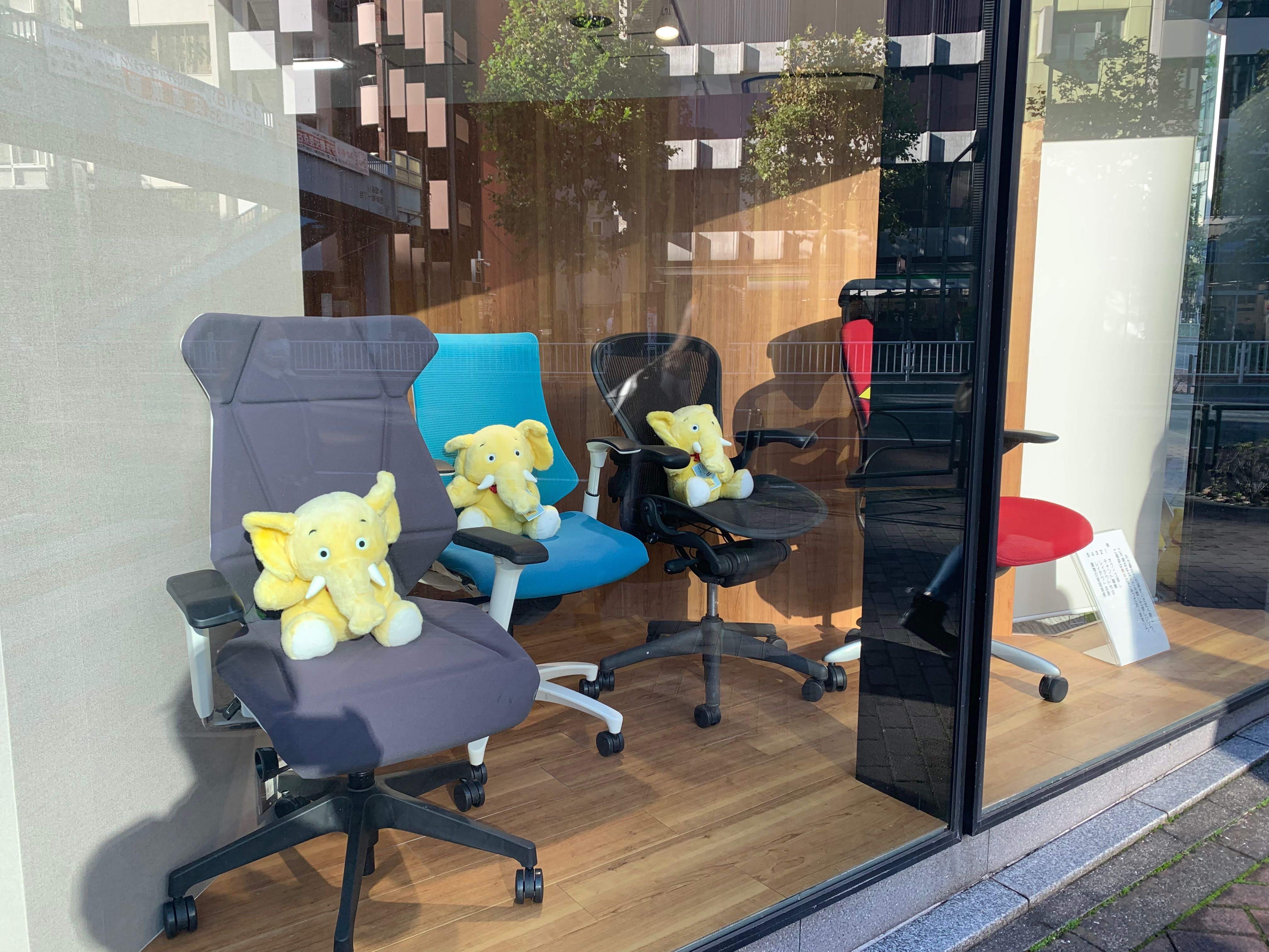 椅子に座って行儀よく並ぶニチビルのゾウのぬいぐるみたち